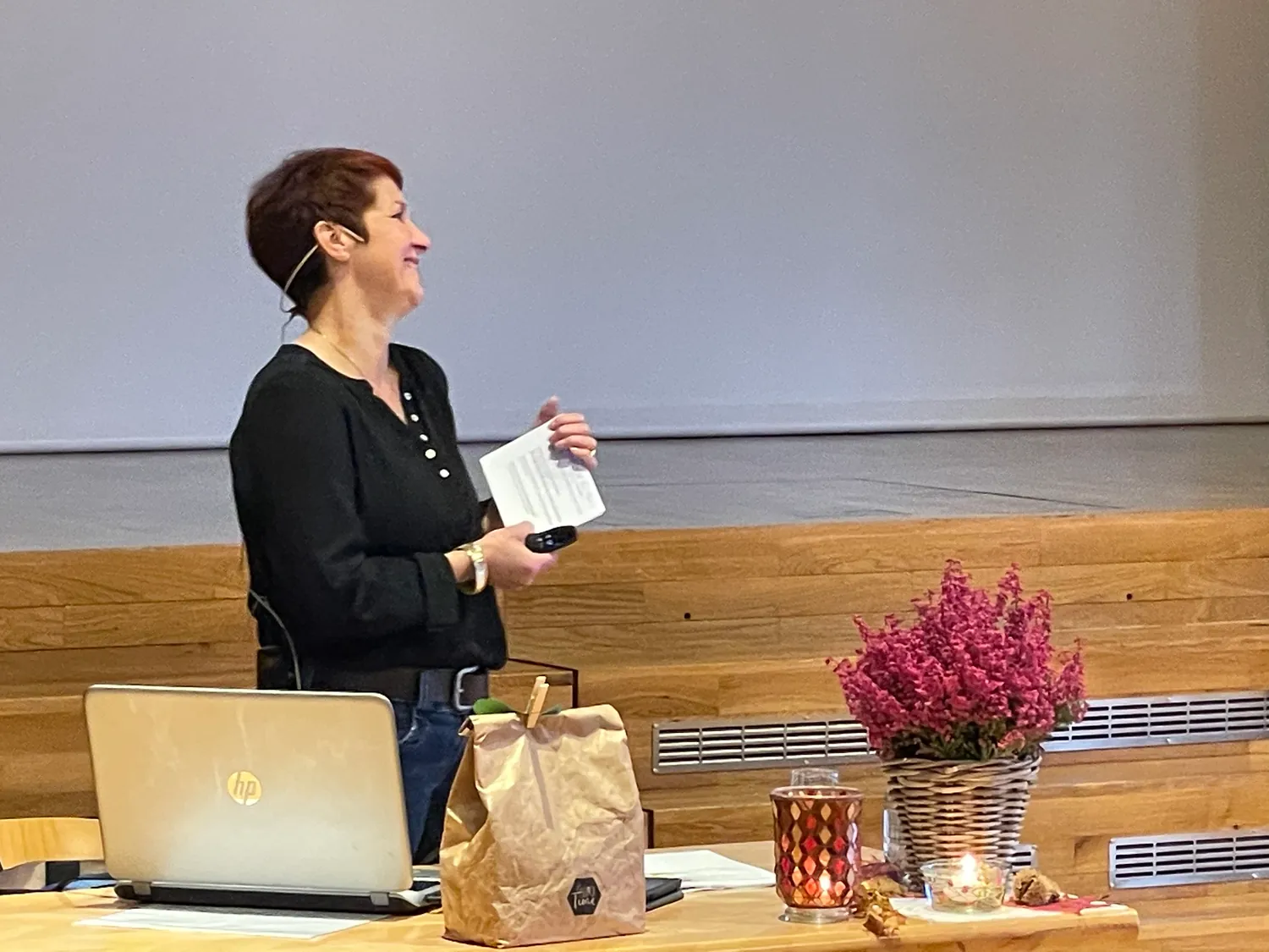 Silvia Zimmermann steht während eines Referats vor der Leinwand, Notizen in der Hand.